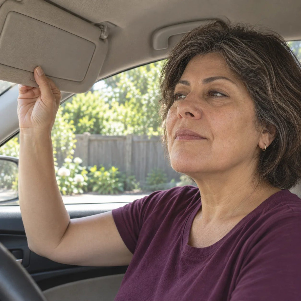 Illustrative parked-car scene of a relaxed woman closing her visor mirror and turning attention to her day
